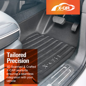 A black textured car floor mat shown installed in a vehicle's footwell, with visible pedals, door sill, and part of the seat. Orange promotional overlays include the X-CAR Auto Supplies logo and text highlighting tailored precision and 3D scanning.