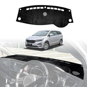 Kia Carnival 2015–2020 black dashboard dash mat installed, custom-fit non-slip dash cover protecting interior from UV damage and reducing windshield glare.