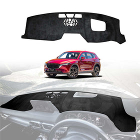 A black dashboard cover mat designed for a Mazda CX5 CX-5, displayed in a position on a white background with a representation of the mat installed on the dashboard of the vehicle.