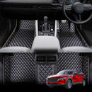 Black floor mats designed for a Mazda CX-30, displayed in the context of the vehicle's interior. The mats have a quilted design and the exterior of the vehicle is shown with a red color scheme.